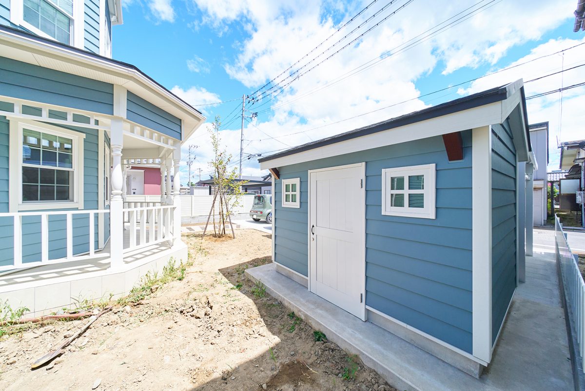 カバードポーチと家とお揃いの外壁材を貼った物置小屋